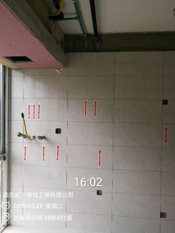 南京武夷名仕園124平米簡美風(fēng)格裝修  享受家?guī)淼臏囟?0五月份_墻磚鋪貼完成后，紅牛裝飾的工人會用專用護(hù)角條對瓷磚角保護(hù)，用標(biāo)貼標(biāo)出水管、線管走向示意。